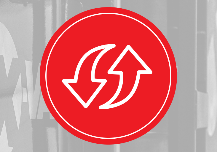 Red circular icon with opposing curved arrows overlaying a grayscale X‑Vac hydro excavation tank, symbolizing vacuum system flow.