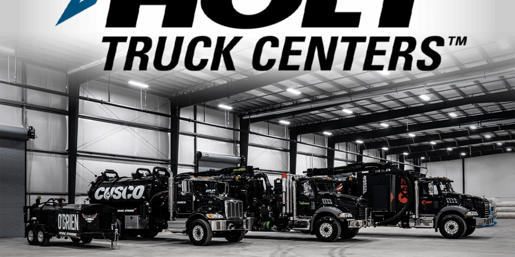Three black Hi-Vac hydro-excavation vacuum trucks parked in a Holt Truck Centers bay under Holt and Hi-Vac logos.