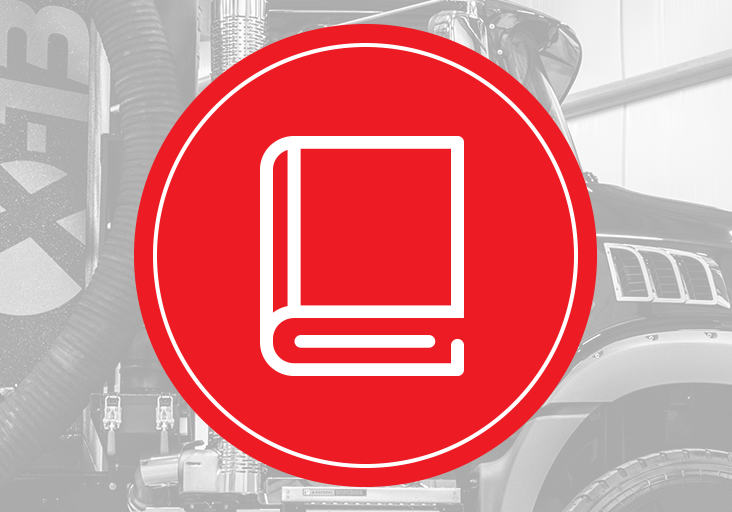Red circular icon with white book/manual symbol over a grayscale X-Vac hydro-excavation truck showing vacuum hose and fender